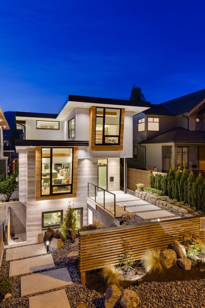 Gey contemporary house exterior in Vancouver with three floors and a flat roof.