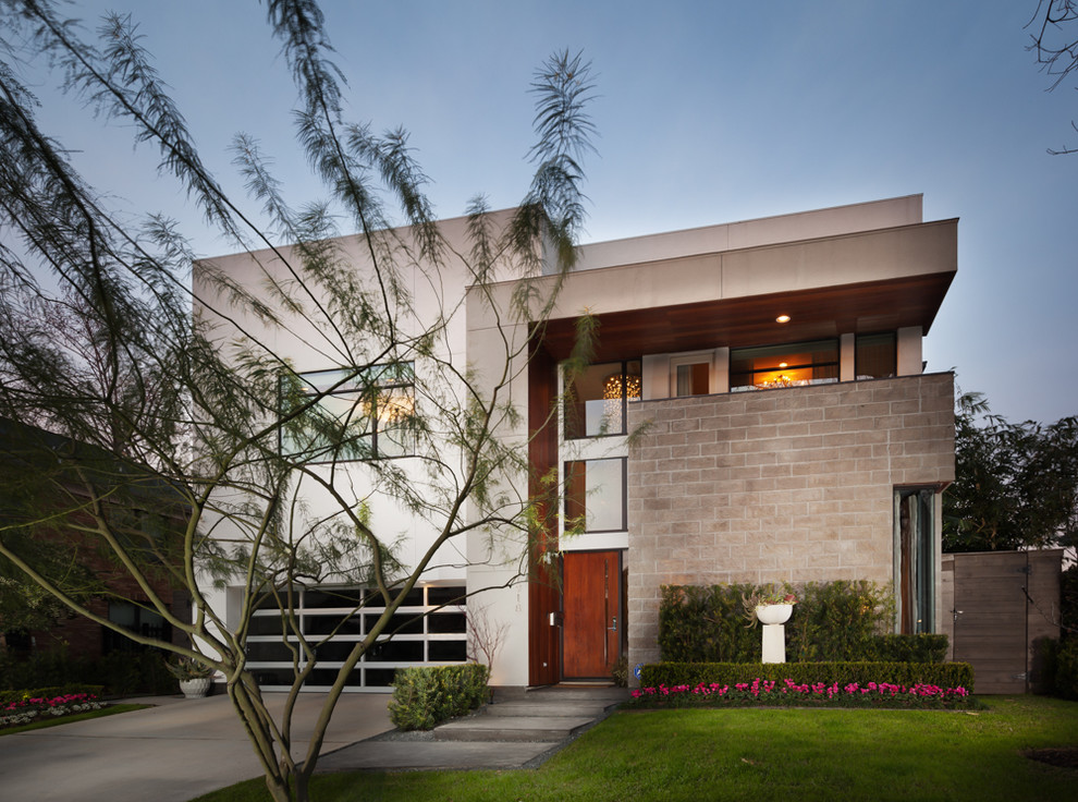 Aménagement d'une façade de maison beige contemporaine en béton de taille moyenne et à un étage avec un toit plat.