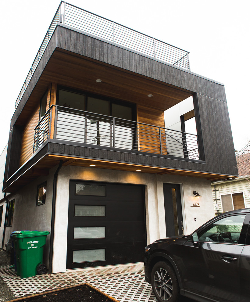 This is an example of a medium sized modern two floor detached house in Seattle with wood cladding.