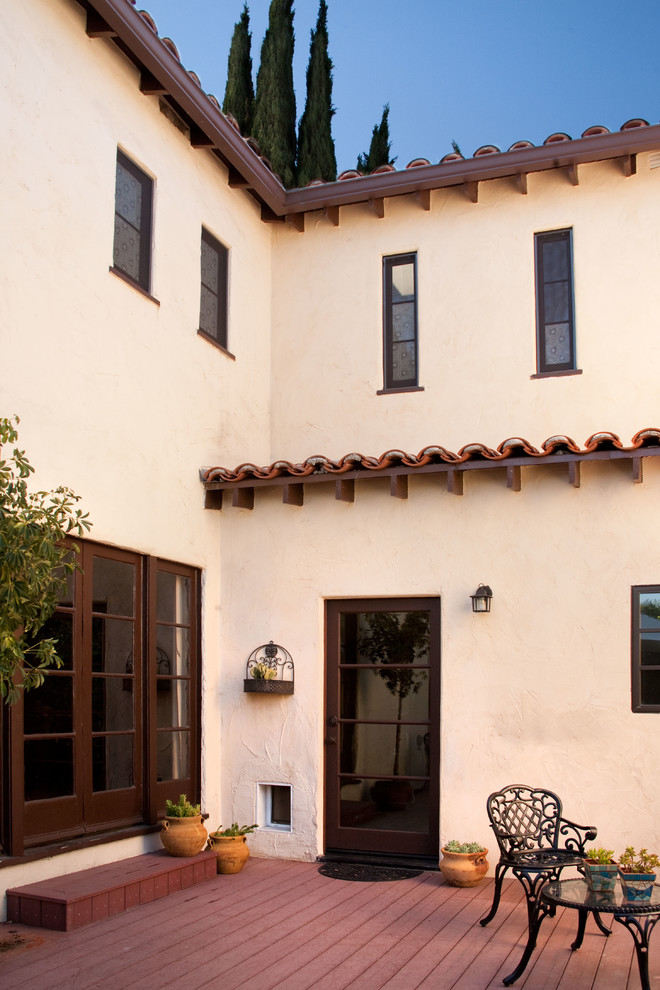 Example of a large tuscan beige two-story adobe flat roof design in Los Angeles