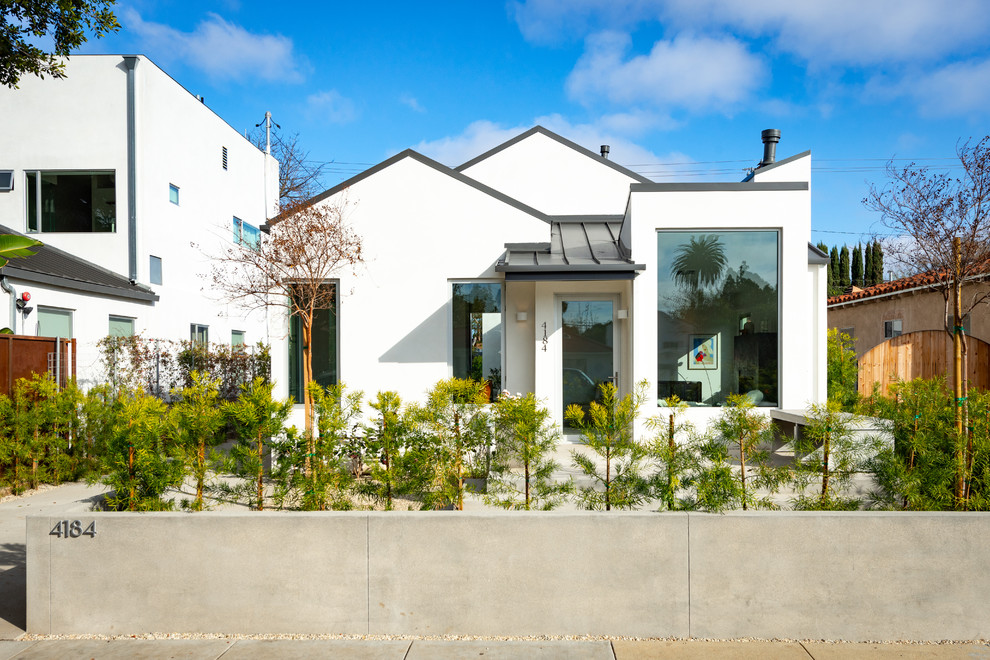 Diseño de fachada de casa blanca contemporánea de tamaño medio de una planta con revestimiento de estuco, tejado a dos aguas y tejado de metal