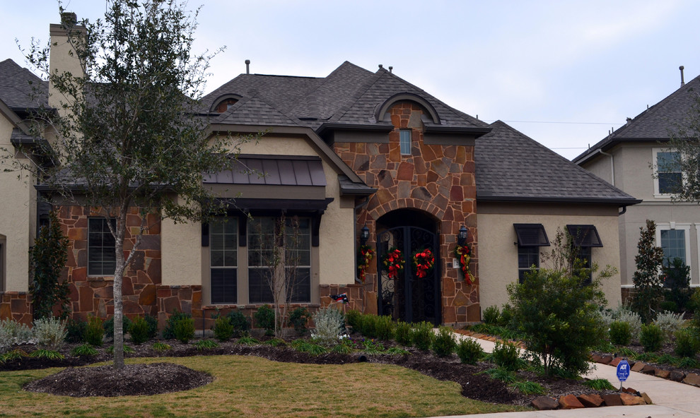 Inspiration for a large and red classic bungalow house exterior in Houston with stone cladding.
