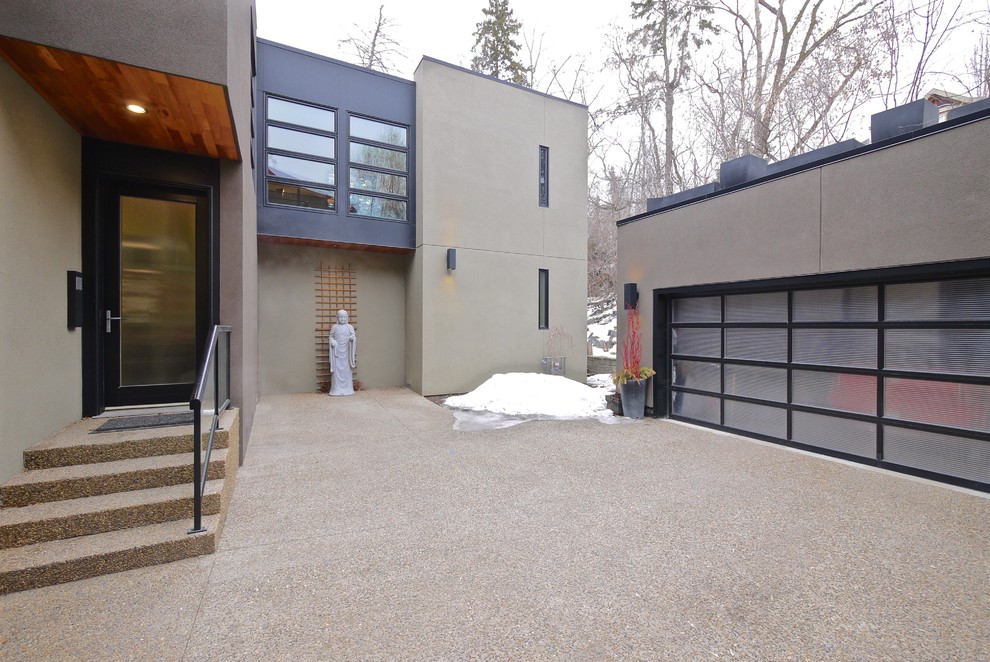 Example of a mid-sized trendy gray two-story stucco flat roof design in Edmonton