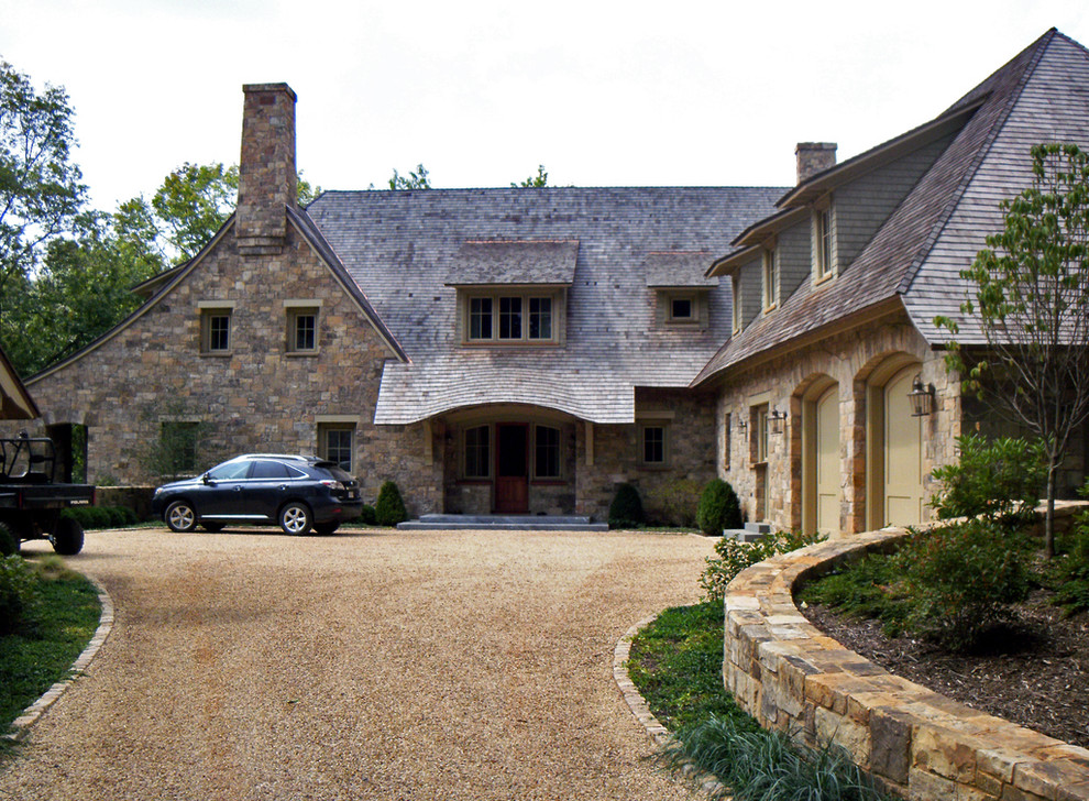 Large elegant two-story stone exterior home photo in Other