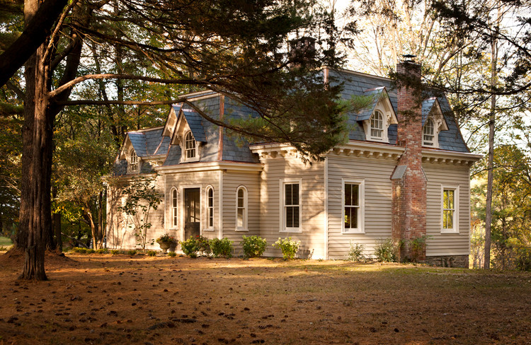 Ejemplo de fachada de casa beige clásica grande de dos plantas con tejado de teja de madera y revestimiento de vinilo