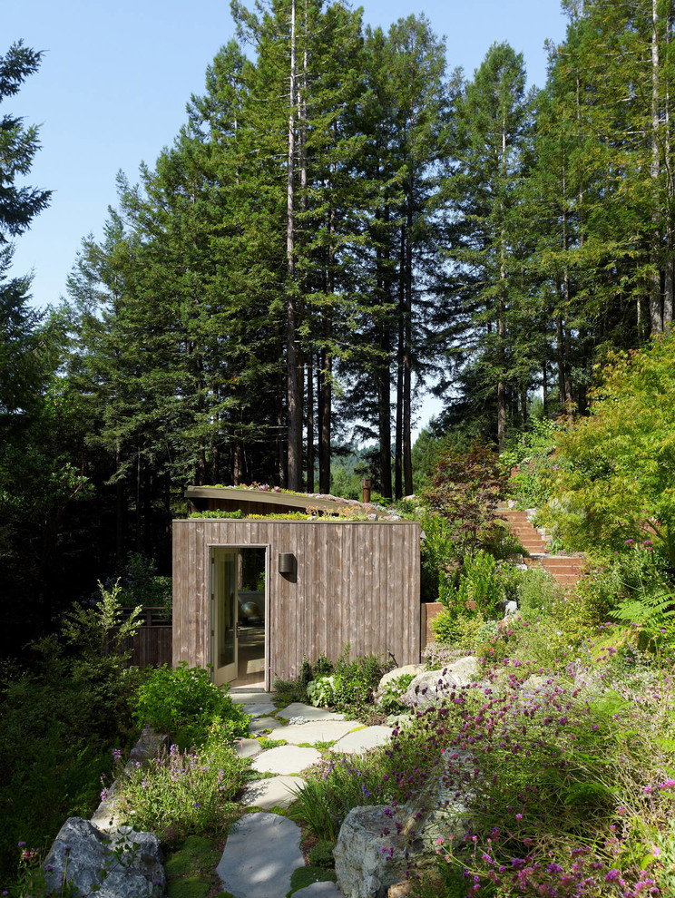 Esempio della villa grande marrone contemporanea a un piano con rivestimento in legno e tetto piano