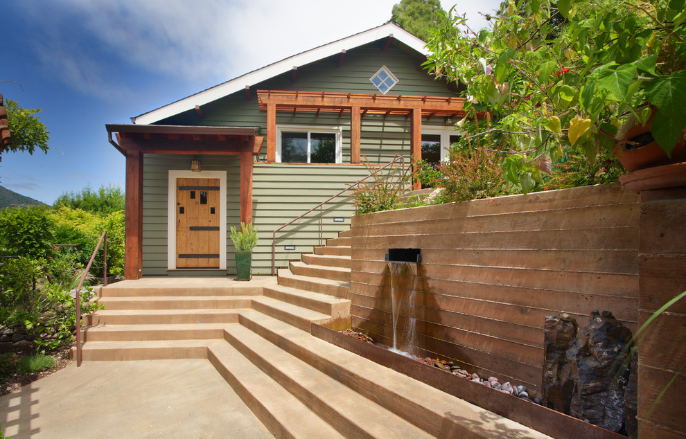 На фото: двухэтажный, деревянный, зеленый дом среднего размера в стиле фьюжн с