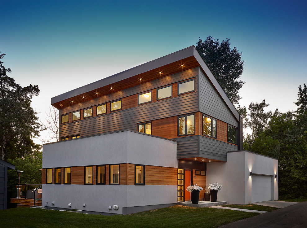 Example of a large trendy white two-story mixed siding house exterior design in Edmonton with a shed roof