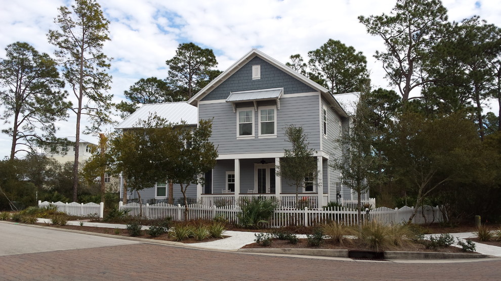 Пример оригинального дизайна: двухэтажный, синий дом среднего размера в морском стиле с облицовкой из винила и двускатной крышей
