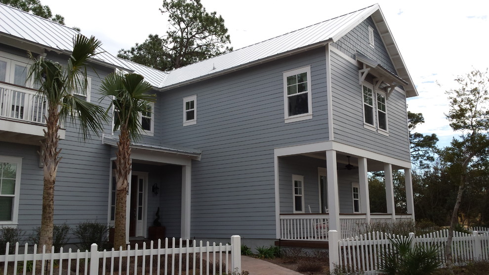 Стильный дизайн: двухэтажный, синий дом среднего размера в морском стиле с облицовкой из винила и двускатной крышей - последний тренд