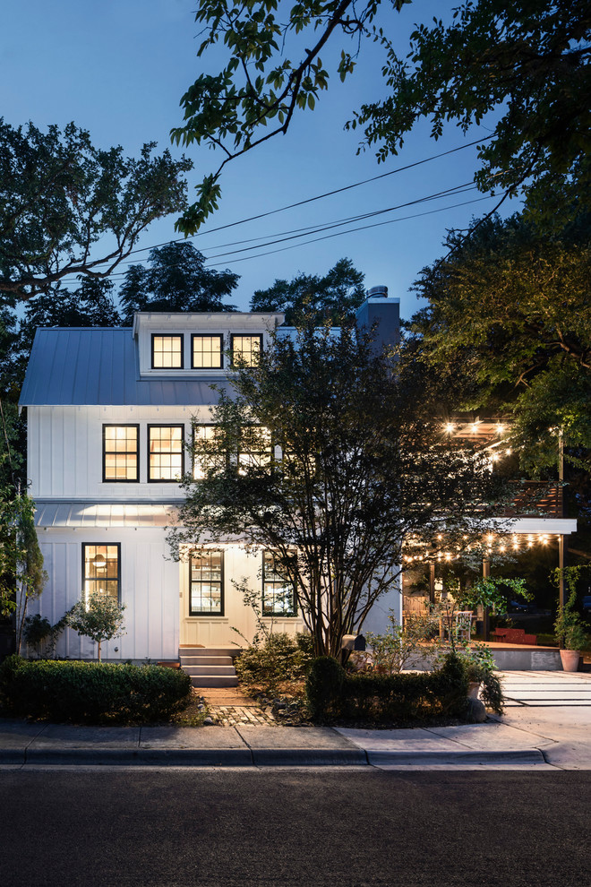 Zweistöckiges Country Einfamilienhaus mit weißer Fassadenfarbe, Satteldach und Blechdach in Austin