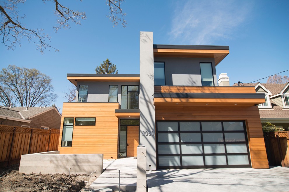 Inspiration pour une grande façade de maison marron design à un étage avec un revêtement mixte et un toit plat.
