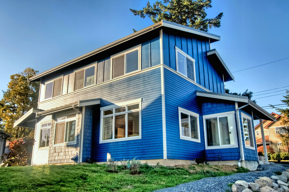 Inspiration för mellanstora moderna blå hus, med två våningar, blandad fasad, pulpettak och tak i metall