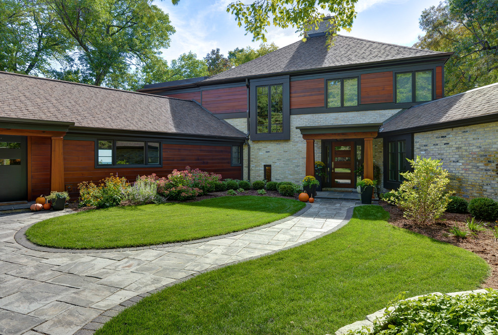 Large trendy multicolored two-story brick exterior home photo in Milwaukee with a shingle roof