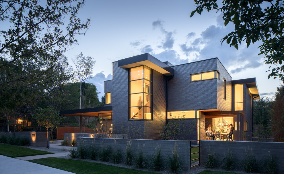 Inspiration for a modern black two-story brick flat roof remodel in Denver