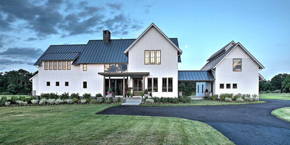 Diseño de fachada de casa blanca de estilo de casa de campo grande de dos plantas con revestimientos combinados, tejado a dos aguas y tejado de metal