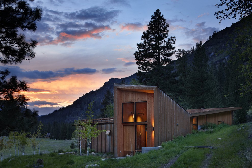 Идея дизайна: маленький, одноэтажный, коричневый дом в стиле рустика с облицовкой из металла и односкатной крышей для на участке и в саду, охотников