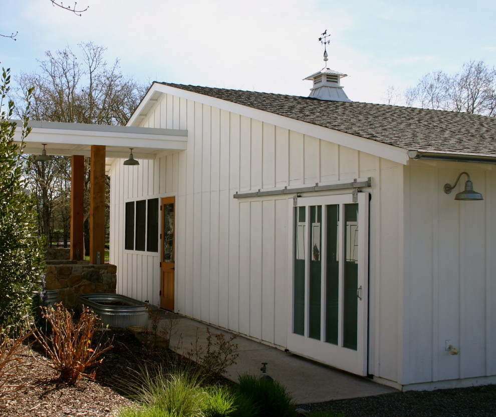 Cette image montre une façade de maison blanche rustique en bois de taille moyenne et de plain-pied avec un toit à deux pans.