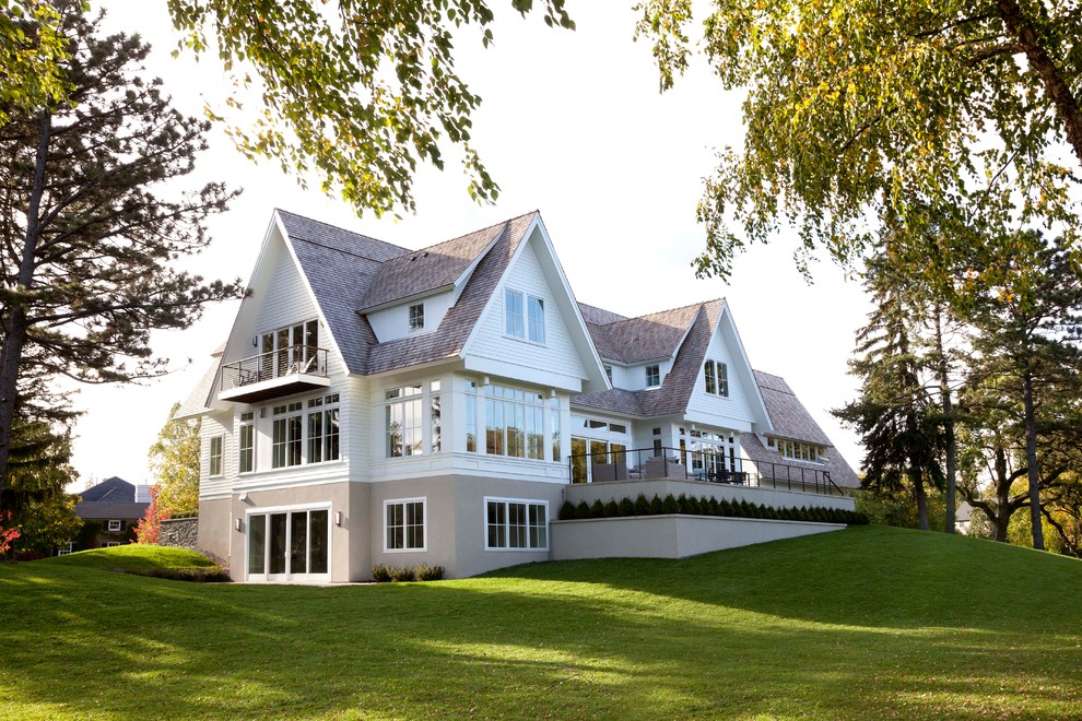 Cette photo montre une façade de maison blanche chic à deux étages et plus avec un toit à deux pans.