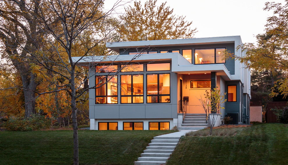 На фото: большой, двухэтажный, серый дом в стиле модернизм с комбинированной облицовкой и плоской крышей с
