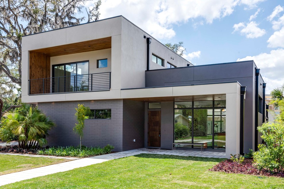 Foto de fachada de casa beige moderna grande a niveles con tejado plano y revestimientos combinados