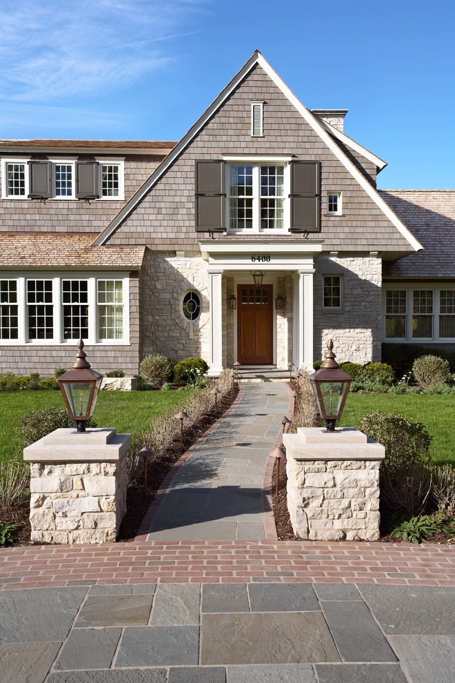 Стильный дизайн: дом в викторианском стиле с облицовкой из камня и двускатной крышей - последний тренд
