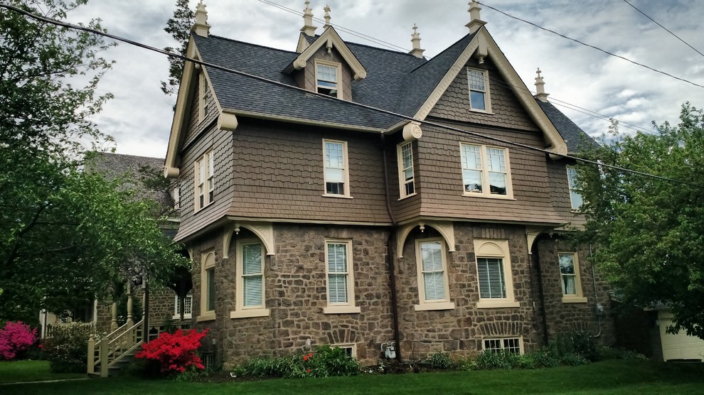 Ispirazione per la facciata di una casa marrone classica a tre piani con rivestimento in pietra