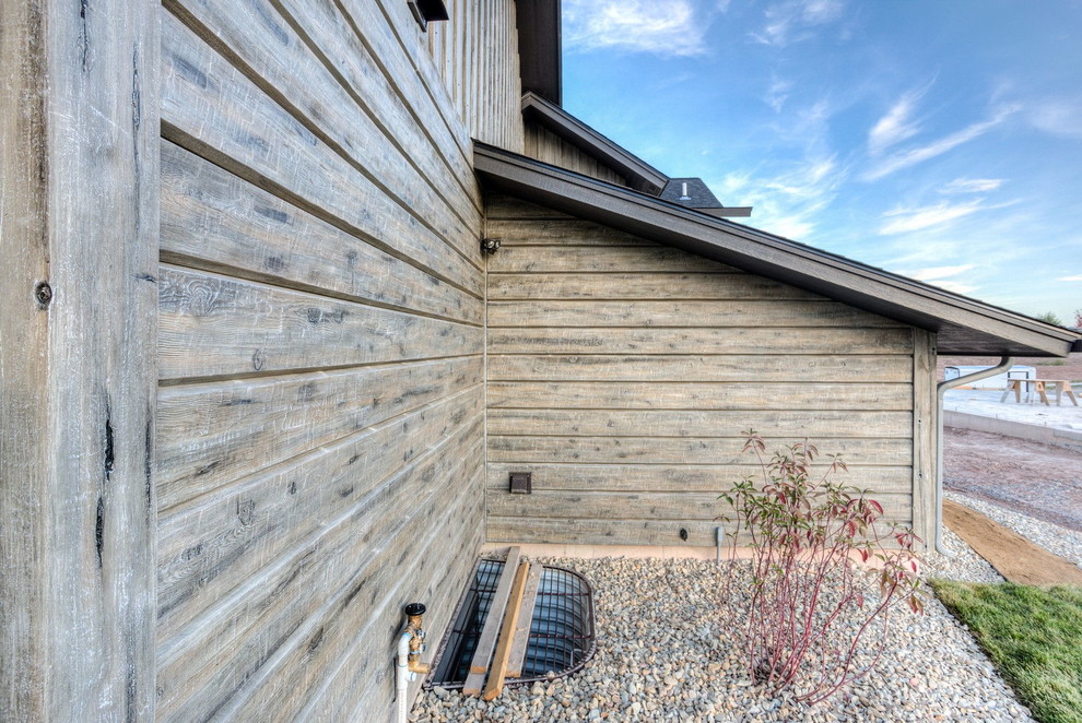 Idée de décoration pour une façade de maison grise chalet en béton avec un toit à deux pans.