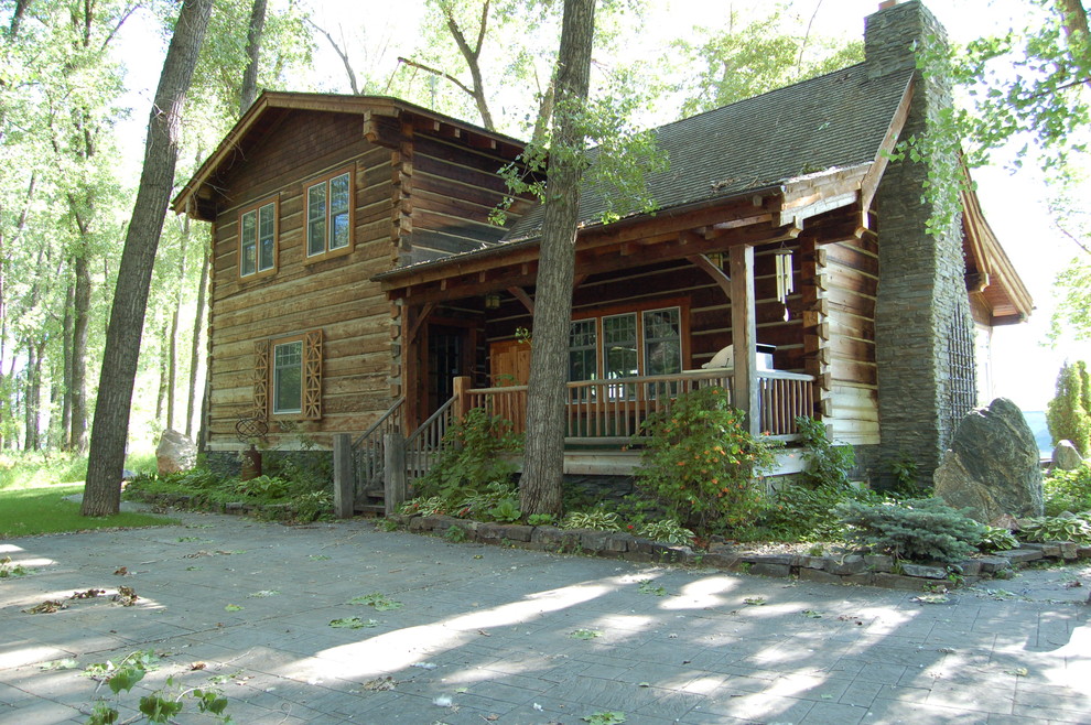 This is an example of a medium sized and brown rustic two floor house exterior in Other with wood cladding and a pitched roof.