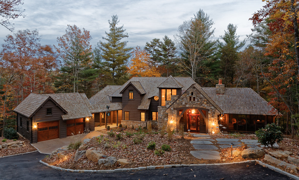 На фото: большой, двухэтажный, коричневый дом в стиле рустика с комбинированной облицовкой и двускатной крышей