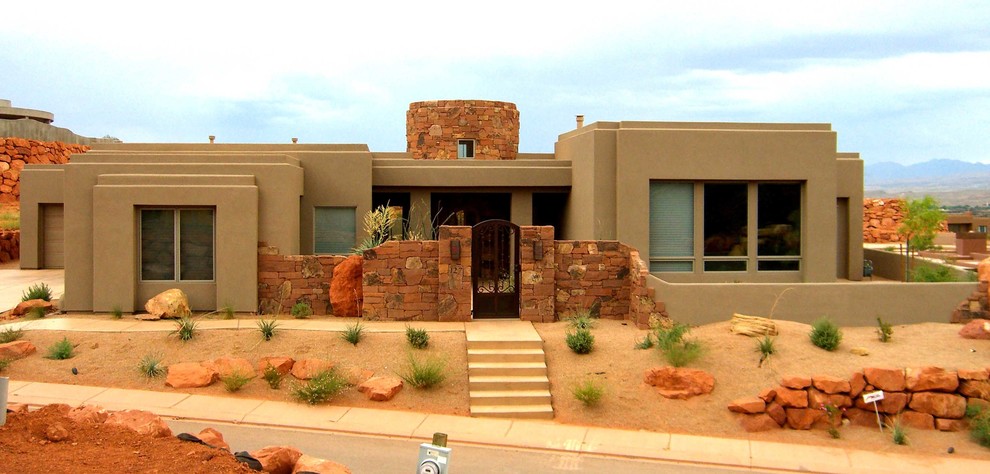 Стильный дизайн: одноэтажный, коричневый частный загородный дом в стиле фьюжн с облицовкой из самана и плоской крышей - последний тренд