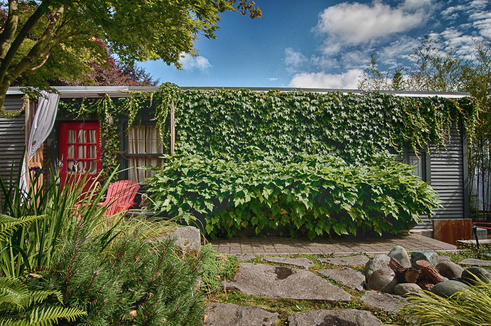 This is an example of a bohemian bungalow house exterior in Portland with metal cladding.