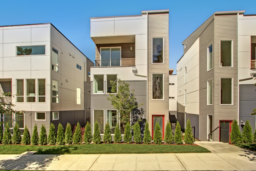 Réalisation d'une façade de maison grise minimaliste à deux étages et plus avec un revêtement mixte.