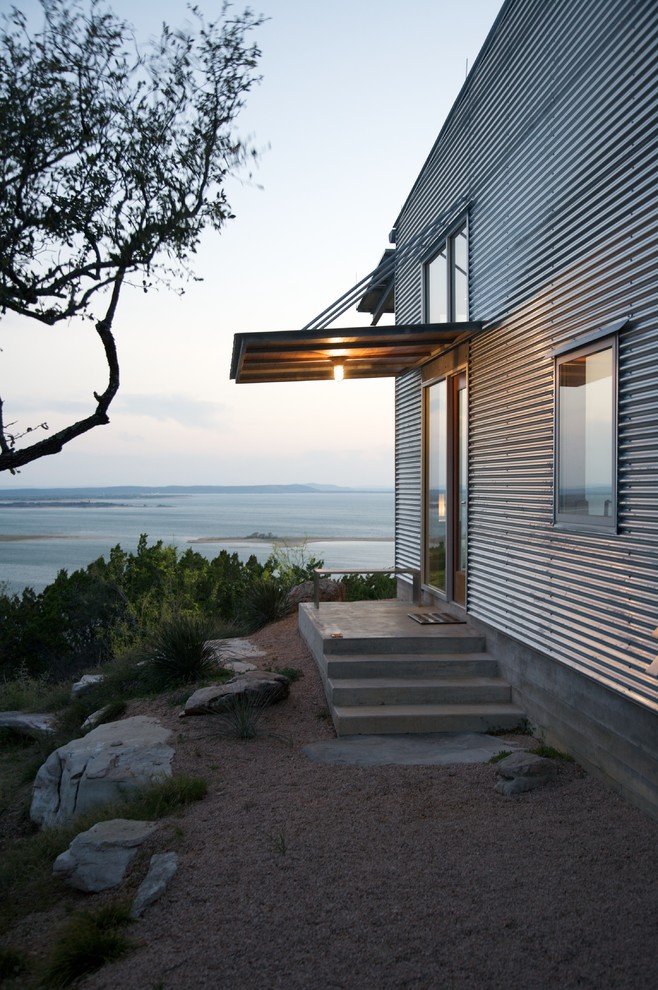 Идея дизайна: маленький, одноэтажный, серый дом в современном стиле с облицовкой из металла для на участке и в саду