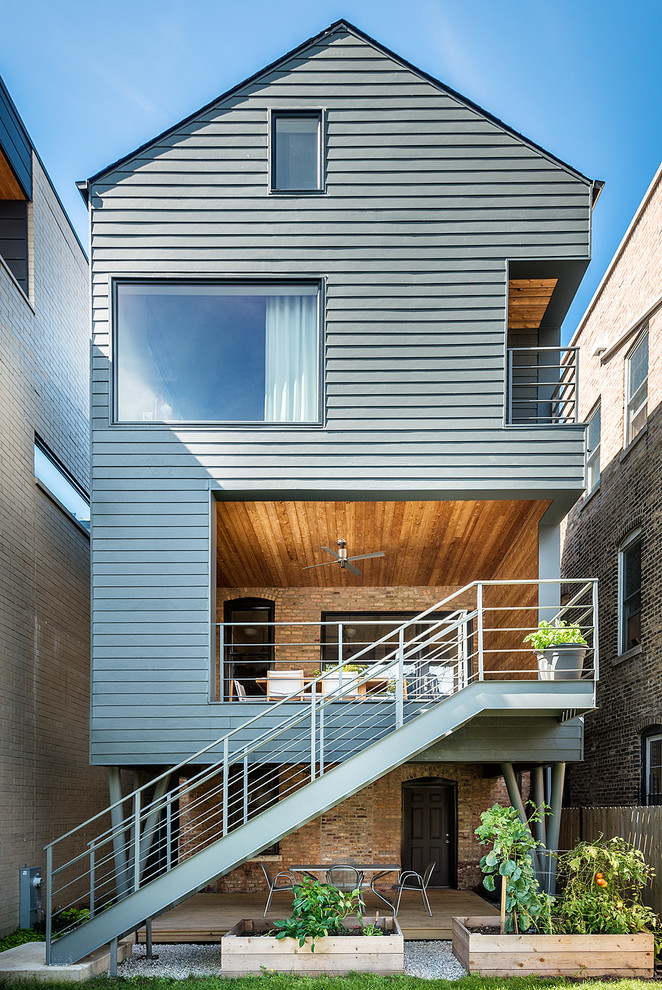 Идея дизайна: трехэтажный, серый дом в современном стиле с двускатной крышей
