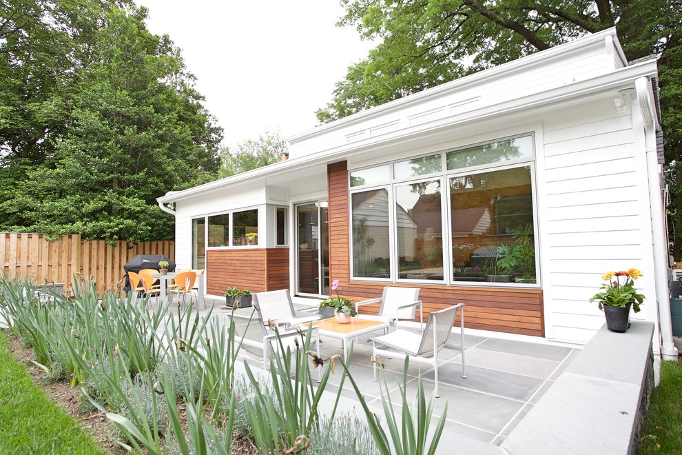 Photo of a medium sized and white modern bungalow house exterior in DC Metro with concrete fibreboard cladding and a lean-to roof.