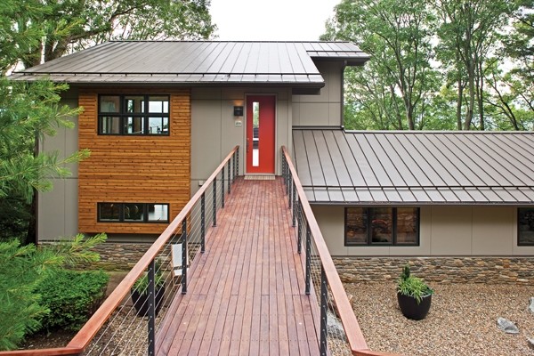 На фото: двухэтажный, серый дом среднего размера в стиле модернизм с двускатной крышей