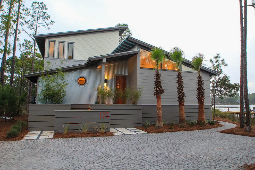 Diseño de fachada gris contemporánea de dos plantas con revestimientos combinados y tejado de un solo tendido