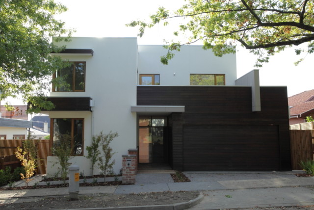 Cette image montre une façade de maison blanche minimaliste en bois à un étage.