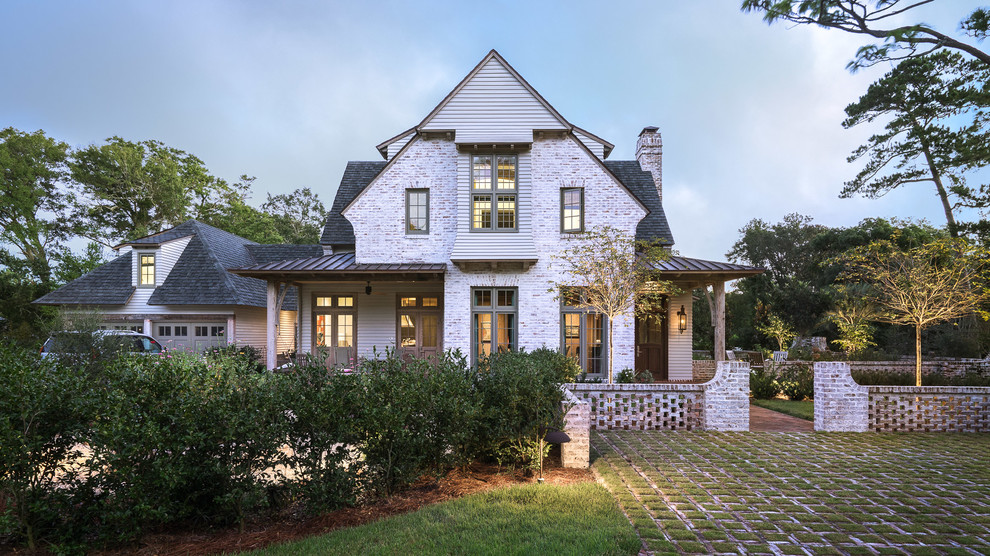 Traditional white two-story brick exterior home idea in Miami with a shingle roof