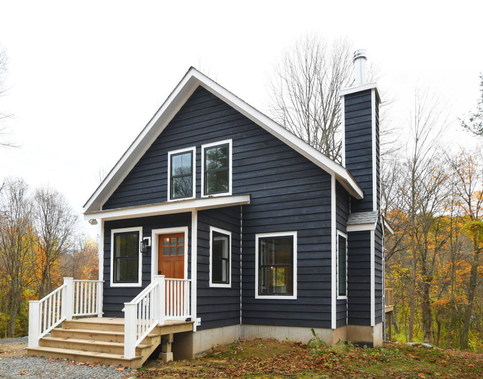 Cette image montre une façade de maison bleue rustique en bois de taille moyenne et à deux étages et plus avec un toit à deux pans et un toit en métal.