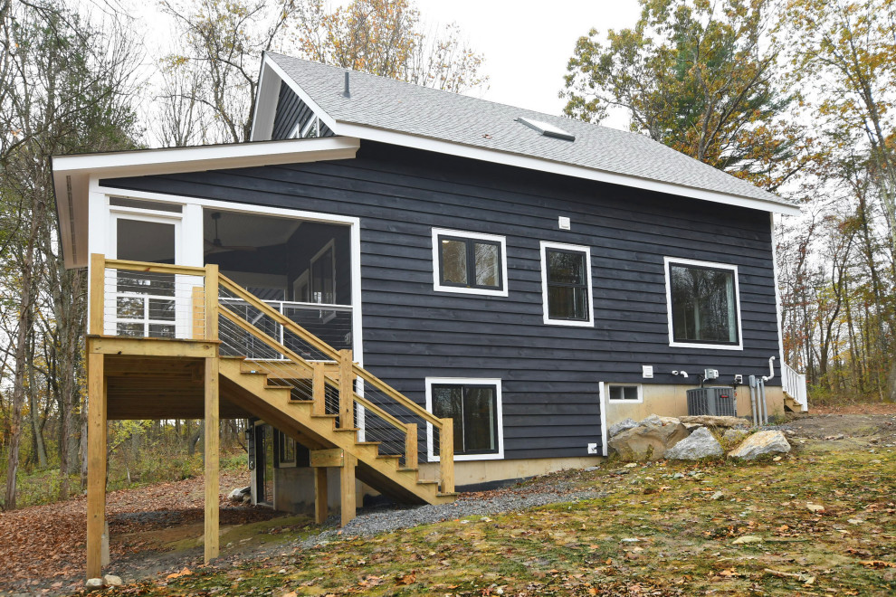 Foto della villa blu country a tre piani di medie dimensioni con rivestimento in legno, tetto a capanna e copertura in metallo o lamiera