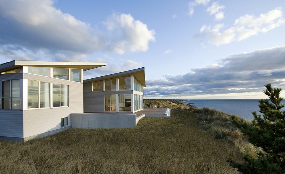 Стильный дизайн: двухэтажный, серый частный загородный дом в стиле модернизм с облицовкой из металла и односкатной крышей - последний тренд