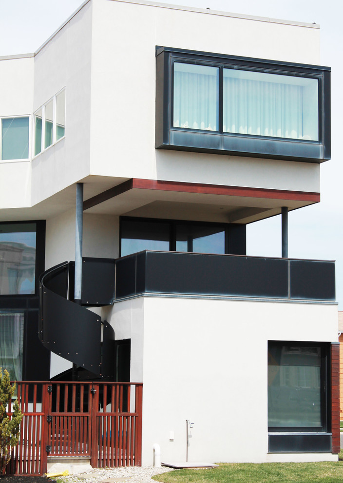 Réalisation d'une façade de maison blanche design à deux étages et plus avec un toit plat.