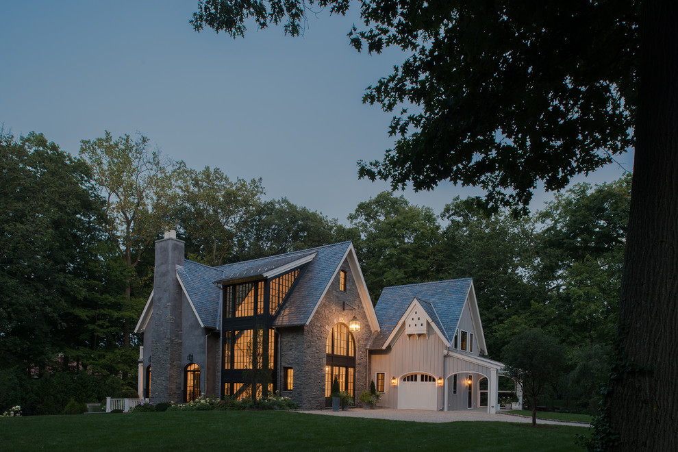 Идея дизайна: трехэтажный, серый, большой частный загородный дом в стиле неоклассика (современная классика) с облицовкой из камня, двускатной крышей и крышей из гибкой черепицы
