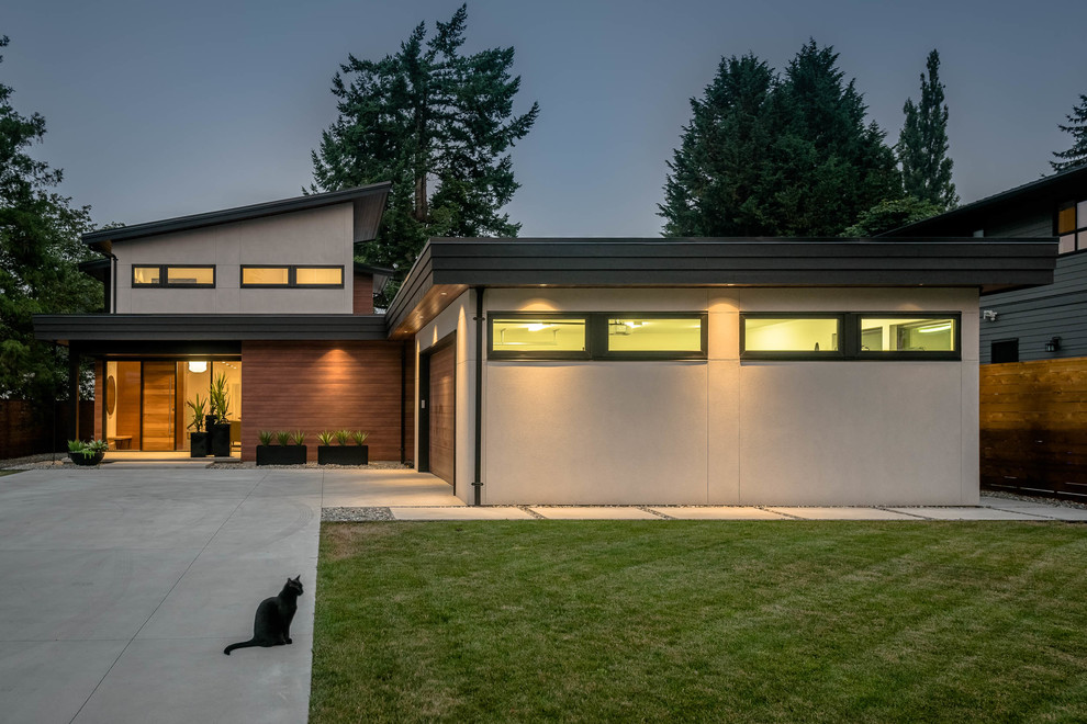 This is an example of a large and beige midcentury two floor detached house in Vancouver with stone cladding, a lean-to roof and a mixed material roof.