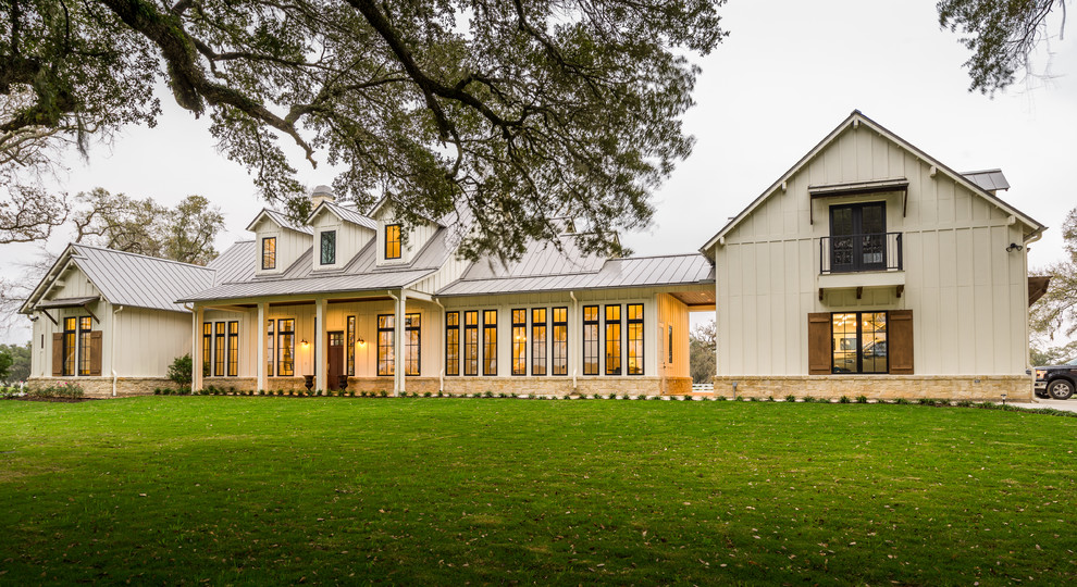 Großes, Zweistöckiges Landhaus Einfamilienhaus mit Faserzement-Fassade, weißer Fassadenfarbe, Walmdach und Blechdach in Houston