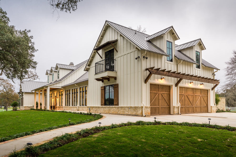 Zweistöckiges, Großes Country Einfamilienhaus mit beiger Fassadenfarbe, Satteldach, Blechdach und Faserzement-Fassade in Houston