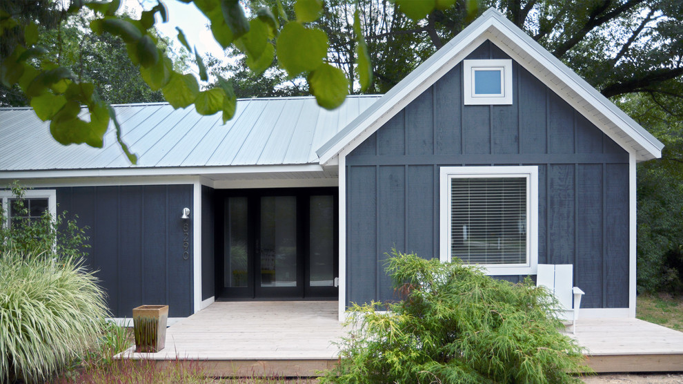 Esempio della villa piccola blu moderna a un piano con rivestimento in legno, tetto a capanna e copertura in metallo o lamiera