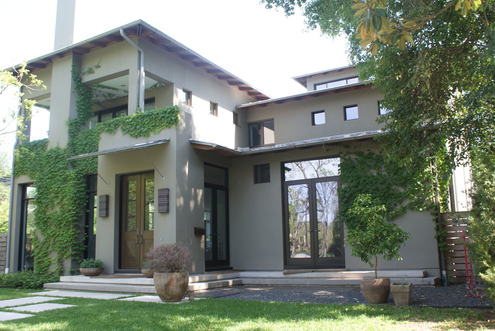 Esempio della facciata di una casa verde moderna a due piani di medie dimensioni con rivestimento in stucco e tetto piano